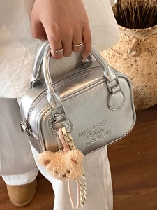 Chic silver metallic pillow bag with dual handles and a cute plush bear charm