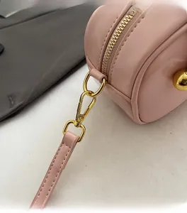 Detail of pink leather Boston bag featuring gold-tone metal zipper and hardware accents