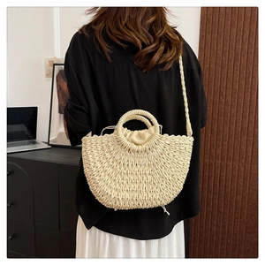 Detail of cream woven straw bag with drawstring lining and versatile crossbody strap