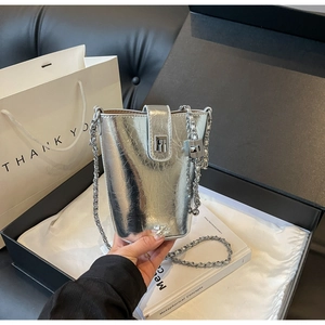 Detailed view of silver metallic bucket bag with chain strap and gift box packaging