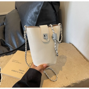 Detailed close-up of a white leather bucket bag with silver chain strap and square metal clasp
