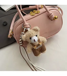 Detailed macro view of pink Boston bag with golden zipper and teddy bear charm
