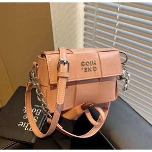 Détail de la texture en cuir tressé rose avec logo en métal argenté sur le sac