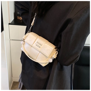 Detailed shot of cream woven crossbody bag with silver metallic logo and bead accents