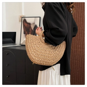 Detailed side view of handmade semi-circular straw woven handbag for summer beach vacation