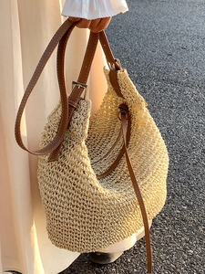 Minimalist beige straw tote bag with brown leather straps for a casual summer style