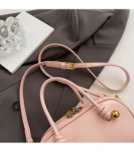 Detailed shot of pink Boston bag with gold hardware and comfortable shoulder strap
