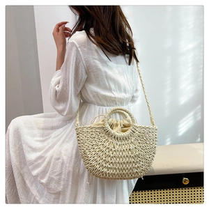 Detail of half-moon straw beach bag with round handles and secure drawstring liner
