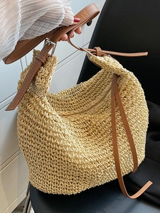 Minimalist straw tote bag with brown leather handles and adjustable shoulder strap for women