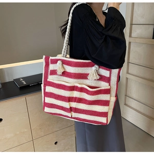 Detail of red and white striped woven tote bag with large front pockets and cotton straps