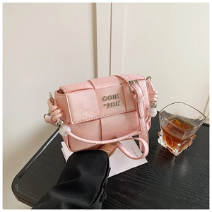 Close-up of pink woven texture bag with metal logo and delicate side bead detail