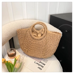 Detail of hand-woven straw basket bag with round handles and secure drawstring liner