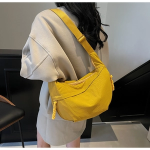 Detailed shot of a bright yellow nylon crescent bag shown with adjustable shoulder strap