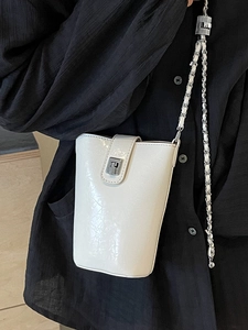 Minimalist white bucket phone bag with silver buckle and metal chain strap for women