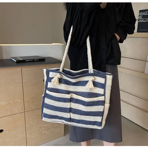 Detail of blue and white striped woven tote with rope handles and front pockets
