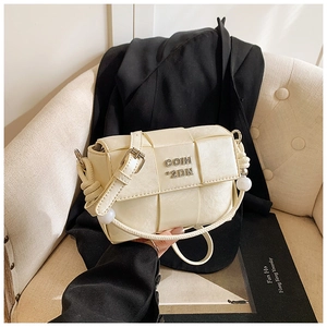 Detail of woven beige leather flap bag featuring pearl charms and metallic logo