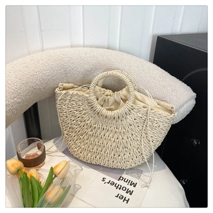 Detailed shot of handmade straw beach bag with woven ring handle and drawstring lining