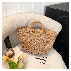 Detail shot of the handwoven straw bag featuring natural texture and drawstring lining