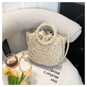 Detail of semi-circular straw bag with woven textures, round handle and drawstring liner