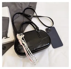 Top view of black oval bowling bag with adjustable strap and decorative heart charm