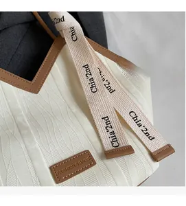 Detail of white wave pattern fabric and brown leather trim on fashion tote bag