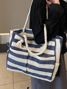 Large woven tote bag with blue and white stripes and sturdy rope handles for travel