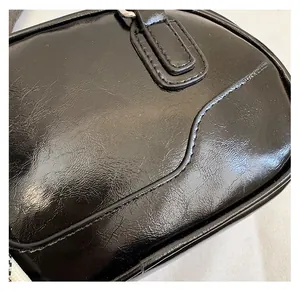 Detailed close-up showing the glossy texture and stitching of the black bowling bag leather
