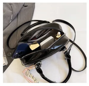 Detail view of large interior capacity and side pockets of the black crossbody bag