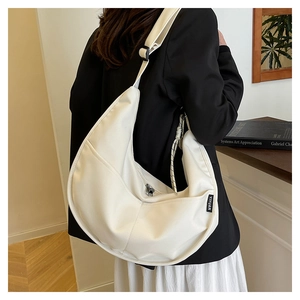 Detail view of white nylon crescent bag with adjustable strap and side brand label