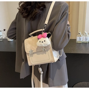 Detail of cream crossbody bag with silver star studs and cute plush pendant charm