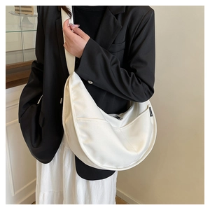 Detail of white crescent bag showing glossy texture and VIVUAN brand woven label