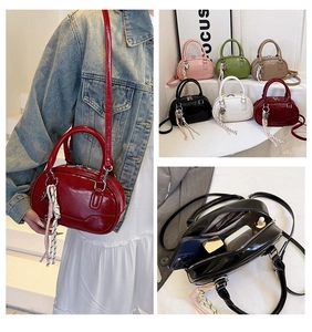 Detail view of mini glossy patent leather Boston bag in various colors with crossbody strap