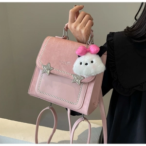Pink faux leather bag detail with pearl trim, star studs and white plush charm