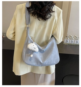 Detail of light blue faux suede crescent bag with a cute white cloud plush charm
