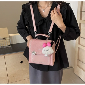 Pink crossbody bag detail showing silver star hardware and cute plush dog charm
