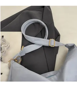 Detail view of the light blue soft leather tote bag with smooth adjustable strap and golden hardware