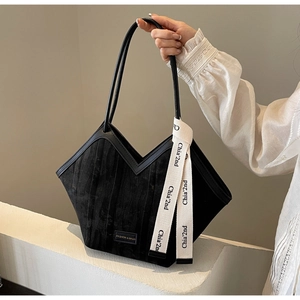 Detail view of the black textured tote bag with V-shaped opening and white ribbon
