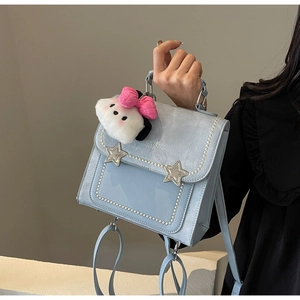 Detail of light blue crossbody bag with pearl accents, star buckles and cloud charm