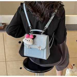 Detail of light blue PU leather backpack with pearl trim and star charms worn on back
