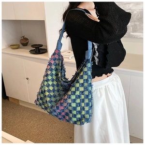 Detailed shot of large tote bag with colorful plaid patchwork and frayed fringe edges