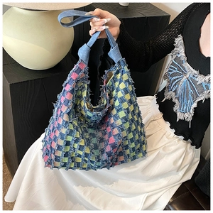 Detail of colorful checkerboard tote bag featuring frayed tassel edges and denim handles