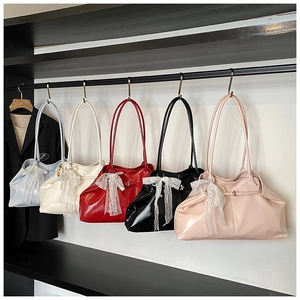 Five trendy leather tote bags in various colors featuring decorative white lace bows