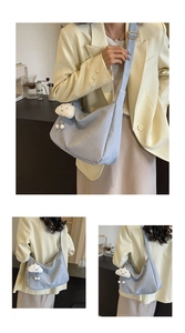 Detail view of light blue soft leather hobo bag with a white cloud plush charm for women