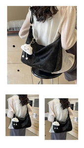 Detail of black matte leather tote bag featuring a cute white cloud plush pendant