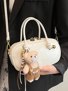 Minimalist white patent leather Boston bag with a cute plush bear charm for daily use