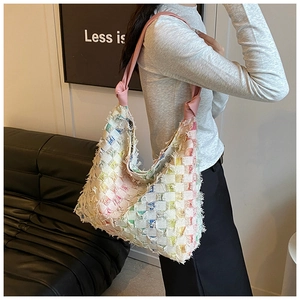 Detail of colorful checkered weave tote bag with fringe edges and knotted pink shoulder strap
