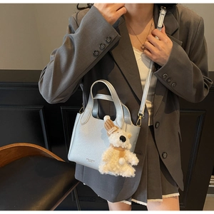 Detail of silver lychee pattern bucket bag with cute bear charm and adjustable strap
