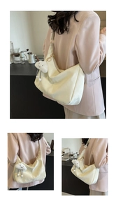 Detail view of cream leather hobo bag with gold hardware and white cloud charm