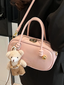 Pink Boston handbag with unique knot handles and a cute bear pendant for daily commuting