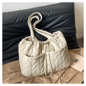Detailed view of the wavy quilted texture and functional front pockets on tote bag